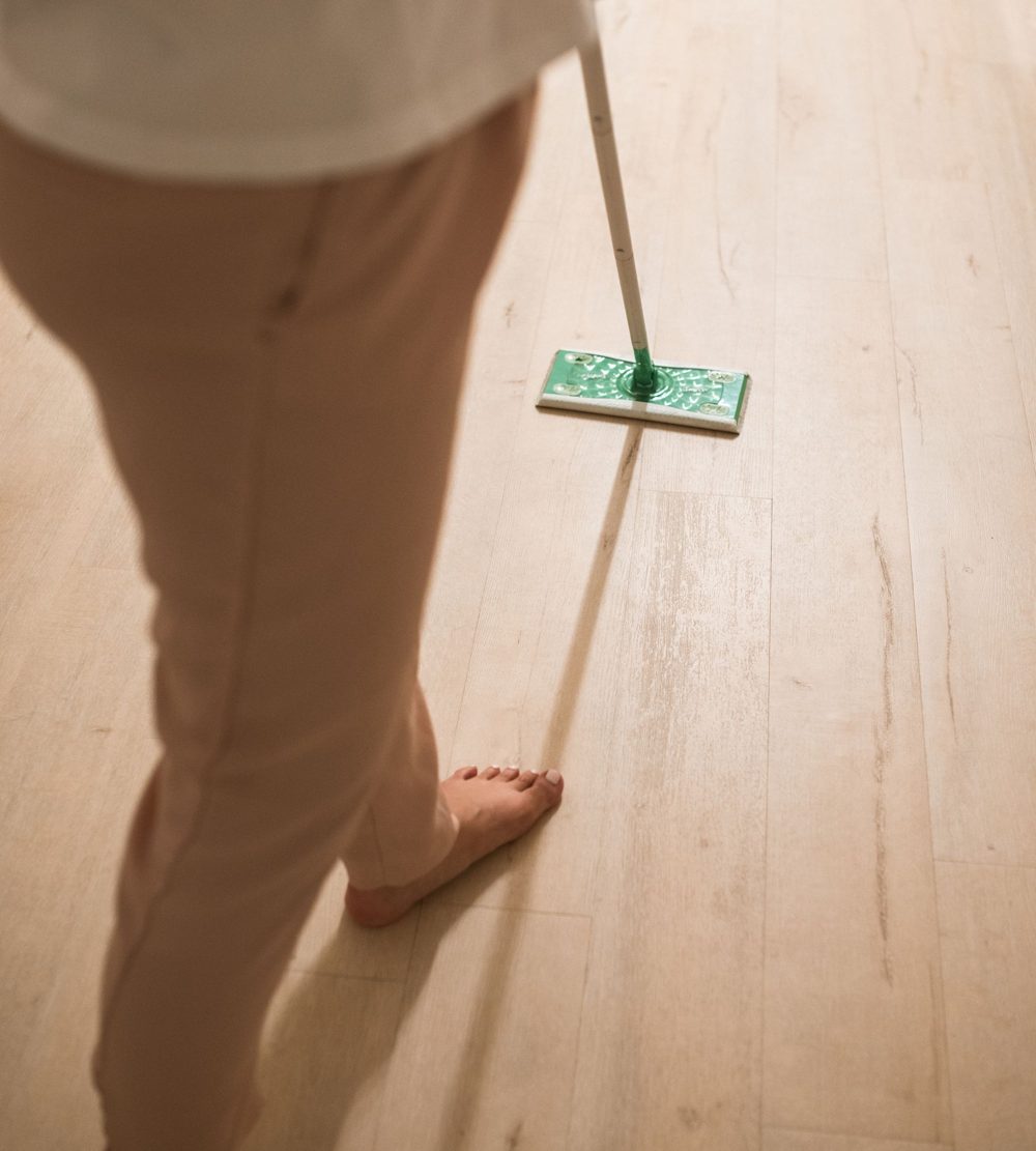 Microfiber mop cleaning a light wood floor