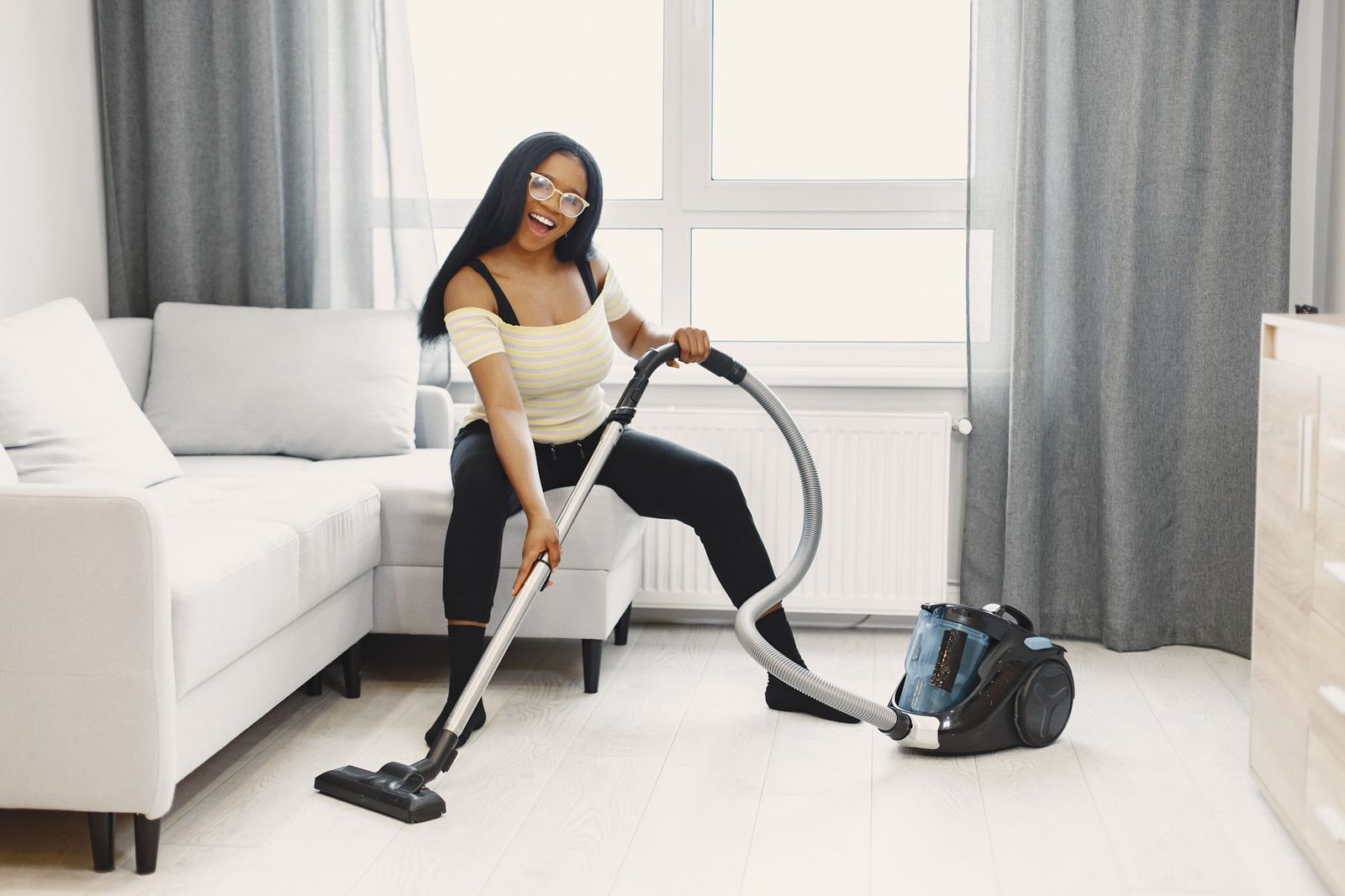 Vacuuming a white living room during a regular house cleaning